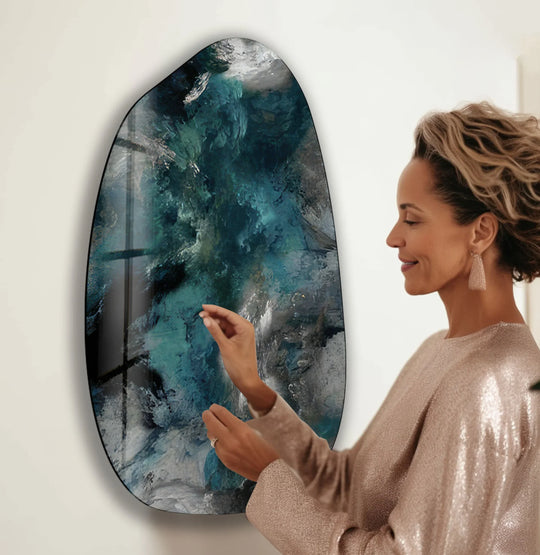 A woman admires the stillness of a modern grey abstract irregular glass wall artwork.