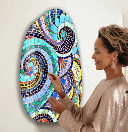 A woman admires a shimmering mosaic glass wall art, a vibrant home decor piece with a glossy finish.