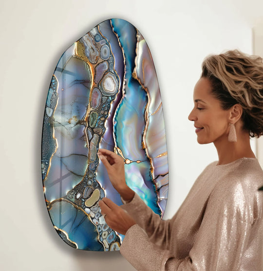 A woman admires a large, oval purple pearl glossy aesthetic glass wall art piece with loud, swirling iridescent blues and golds.