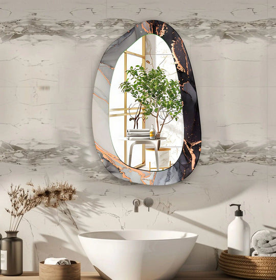 Asymmetric glass mirror with gray black and gold abstract design reflecting a plant and table as a modern bathroom accent