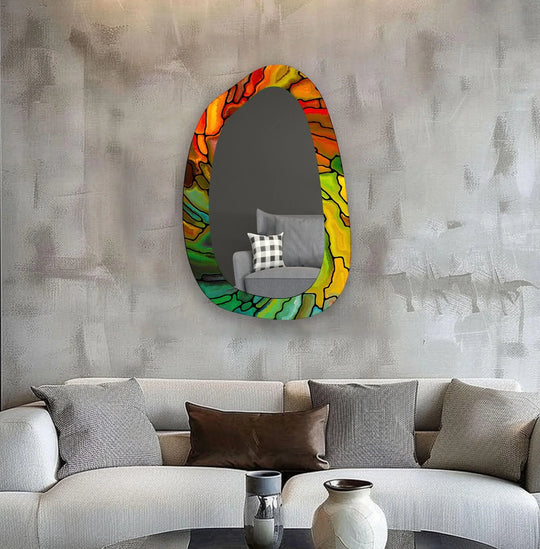 Vertically oriented and abstractly shaped, this bedroom wall mirror features a vibrant stained glass style border showcasing modern wall mirrors.