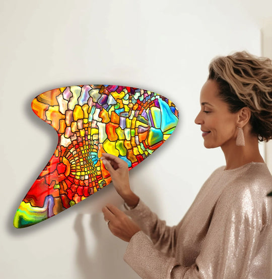 A woman admiring abstract glass art with deep crimson and sapphire stained-glass elements.