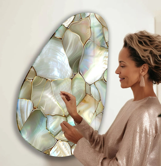 A woman gazes at a shimmering, irregularly shaped piece of glass wall artwork with ample negative space around it.
