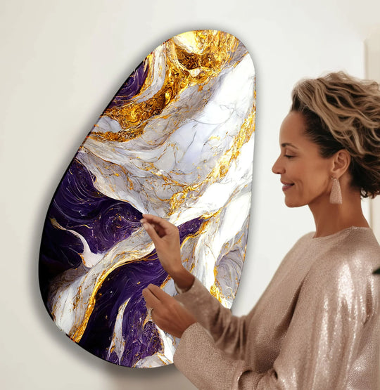 A woman admires a large, ovular abstract hanging wall art with deep purple and white marble patterns complemented by opulent gold accents, emphasizing the surrounding empty space.