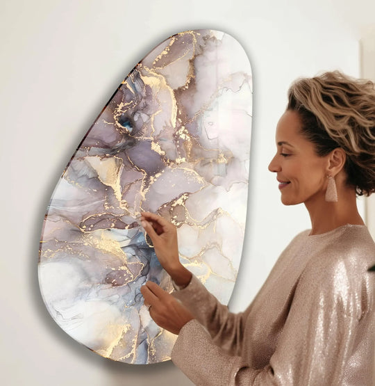 A woman admires best glass art featuring layered abstract watercolor with ethereal blues and shimmering gold accents.