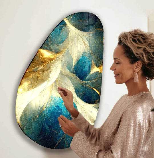 A woman admires the deep, layered blues and golds of this stunning glass wall art.