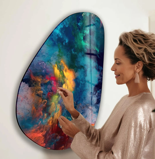A woman admires a unique modern wall decor with a cool color temperature featuring vivid blues and abstract patterns.
