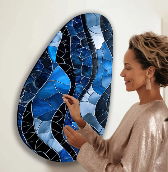Abstract glass wall art prints convey a sense of dynamic movement with swirling sapphire and navy blue mosaic patterns.