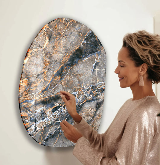 A woman admires the moody, abstract patterns of a unique glass wall art decor piece.