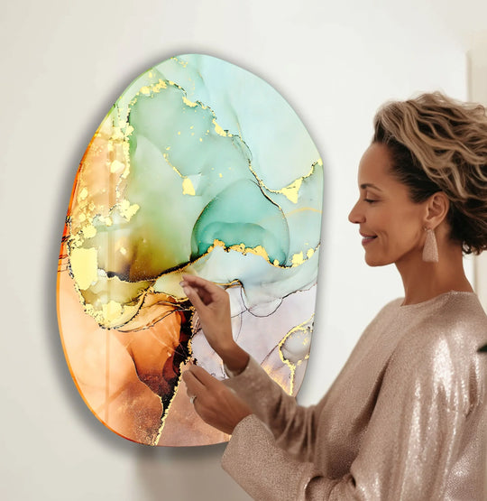 Abstract alcohol ink swirls of green and gold on an oval hanging wall art piece captivate with their organic elegance.