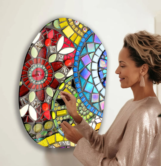 A woman touches the textured edge of a vibrant oval mosaic glass wall art, perfect for home decor.