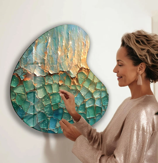 A woman admires a unique modern wall decor with organic, crayon-like forms in light green and gold hues.