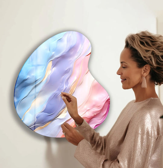 A woman admires the tranquil flow of colors in a unique modern wall decor glass art piece.
