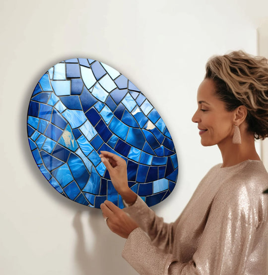 Woman admires the softest shimmer of gold dust within a vibrant blue mosaic glass printing.