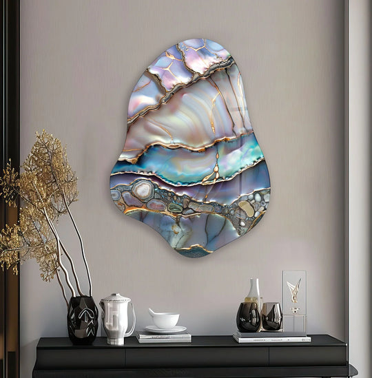 A textured, neutral-toned wall serves as the subtle backdrop for a striking piece of abstract glass printing.