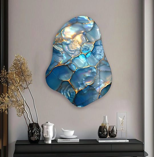 Stylish blue abstract irregular glass wall art with metallic gold borders and accents on a plain wall.
