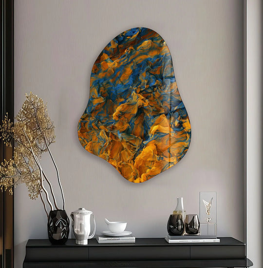 An irregularly shaped, abstract glass wall art print featuring swirling patterns of orange and blue.