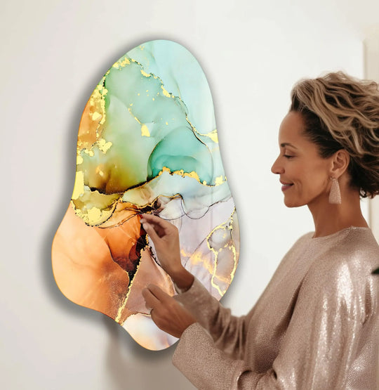 A woman touches an abstract turquoise alcohol ink design, creating best glass art on a stylish surface.