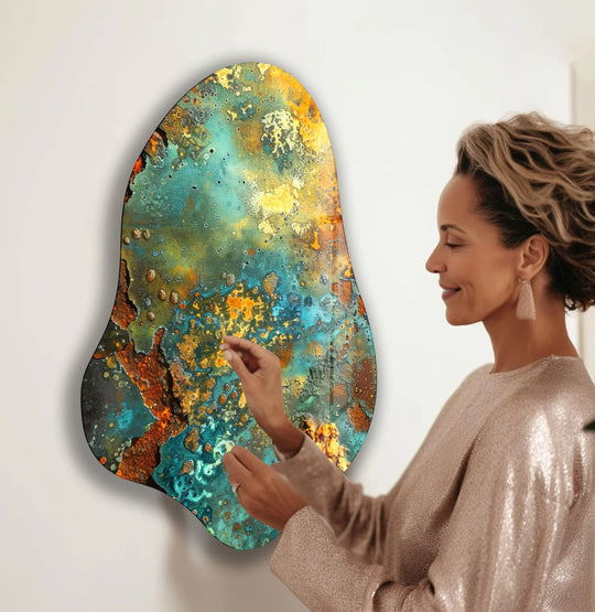 A woman admires the swirling organic forms of abstract green glass wall artwork with vibrant, natural textures.