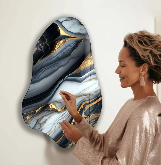 Abstract glass art with swirling gray and gold marble patterns create a luxurious, irregular-shaped wall hanging.
