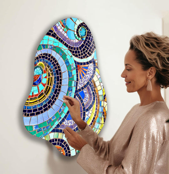 A woman in a shimmering dress admires the soft, undulating curves of a colorful mosaic glass decorative wall art.