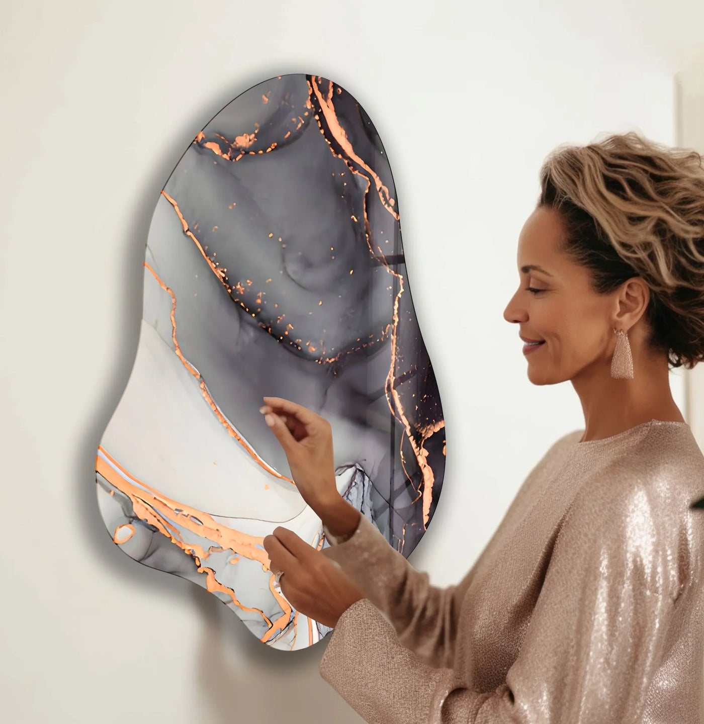A woman admires the elegant, shimmering finish of this irregular glass wall art with abstract gray watercolor design.