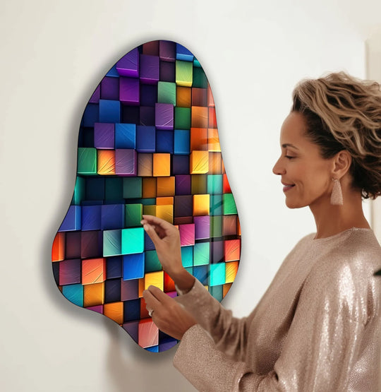 A woman admires a colorful, irregularly shaped hanging wall art with a captivating organic form reminiscent of flowing ribbons.
