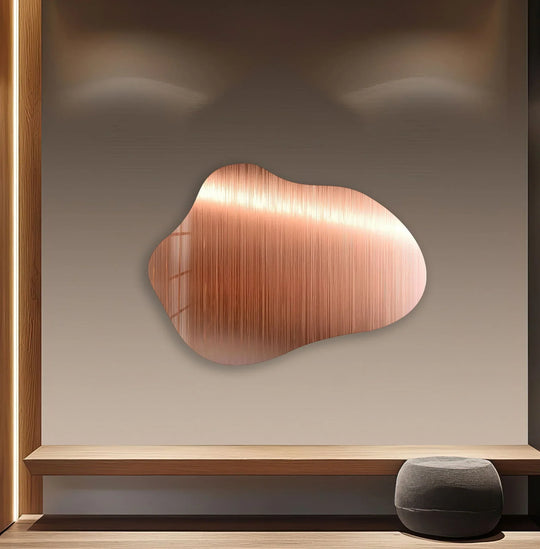 A dark shadow accentuates the undulating, rose gold metal wall art, highlighting its textured finish.