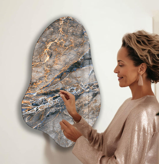 A woman admires elegant grey marble hanging wall art with dominant grey and bronze tones.