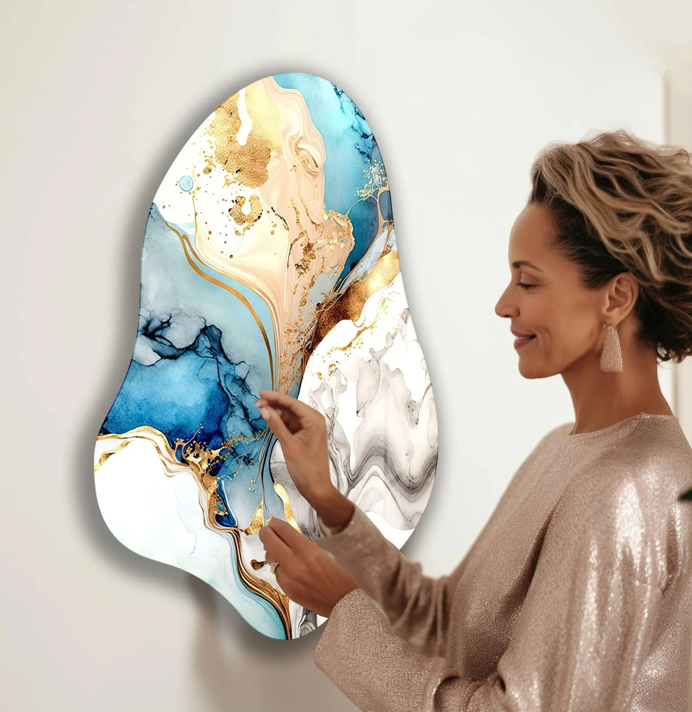 Abstract glass wall art with a glistening metallic finish of gold, blue, and white alcohol ink swirls.