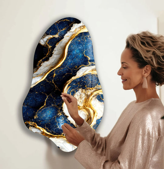 The striking edge of this abstract blue marble glass wall artwork features a unique asymmetrical border with intricate gold veining.