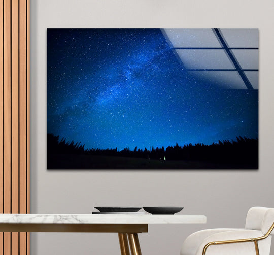 Dominant deep blue hues illuminate the Starry Night Sky Wall Art glass print, enhanced by the reflective surface due to the unique glass printing technique.