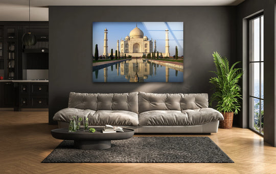 Foreground detail reveals a styled black coffee table with lime-infused water and a book set on a woven rug, enhancing the display of Taj Mahal wall art prints.