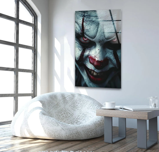 Patterned beanbag chair cushions the hardwood floor near the sinister clown face hanging wall art, creating a cozy contrast.