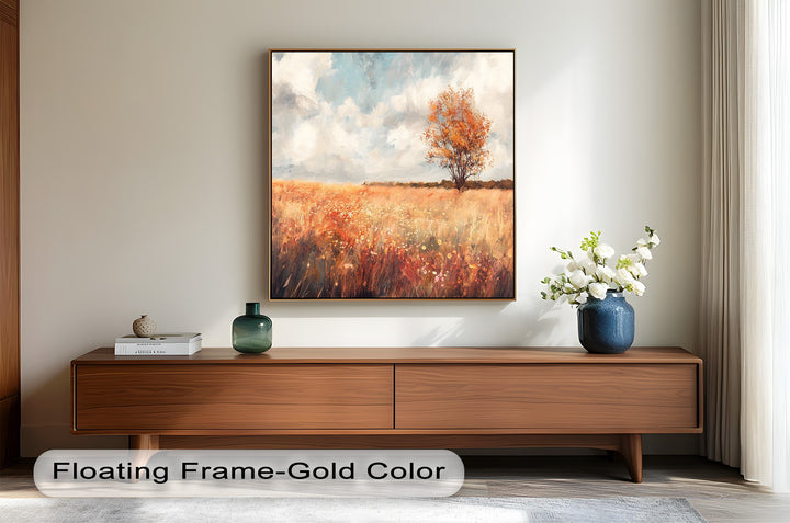 Warm fall landscape artwork featuring a tree under a blue sky.
