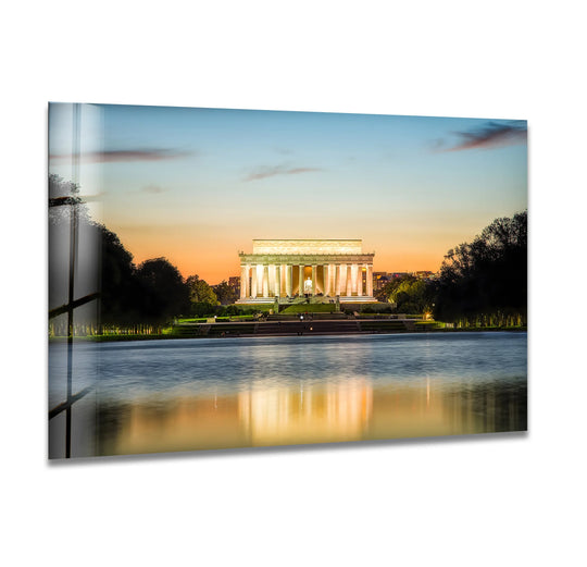 The Lincoln Memorial stands as the focal point in this glass wall art, a stunning piece of home decor that captures the reflective sunset elegance.