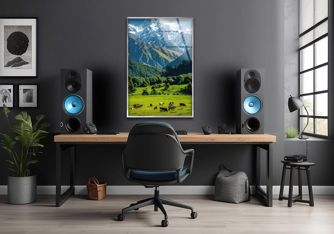 Tranquil countryside view featuring green pastures, livestock, and a breathtaking mountain skyline.
