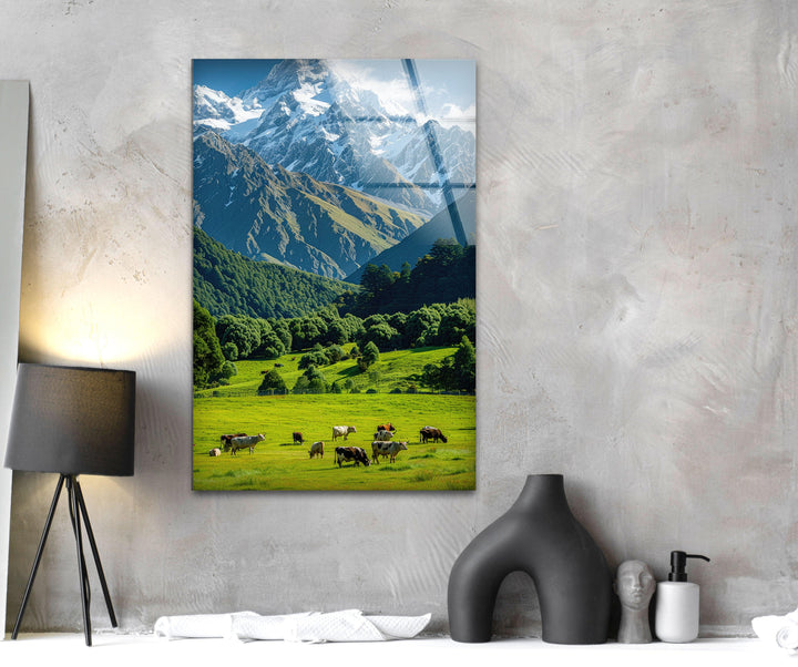 Stunning mountain landscape featuring lush green fields, grazing cows, and majestic peaks.
