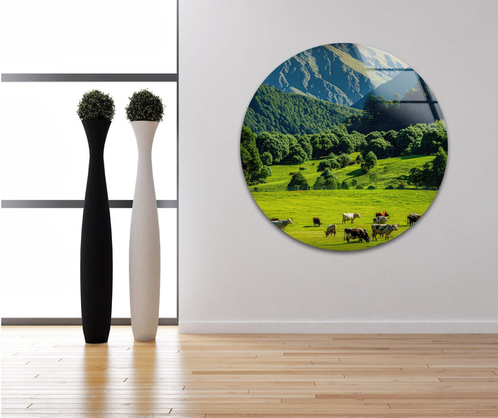 Beautiful alpine scenery with grazing animals and lush greenery against a backdrop of snowy mountains.
