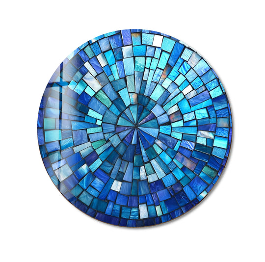 Light and shadow dance across the individual blue mosaic tiles of this round glass wall artwork, enhancing the oceanic radiance of the design.