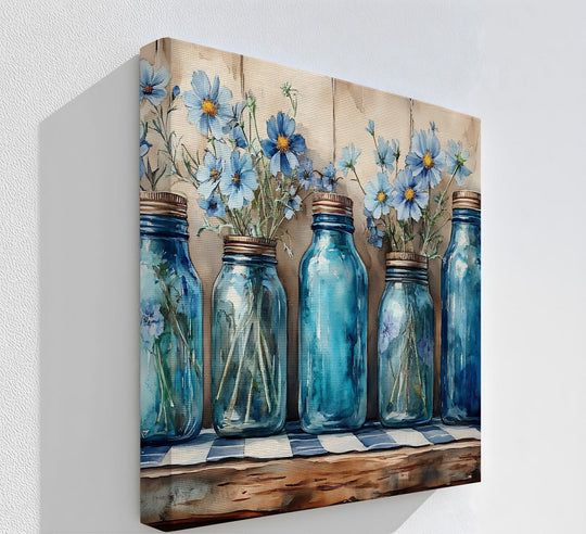 Distinguished by its clean finish, this canvas art presents a rustic still life of vintage blue mason jars and wildflowers, showcasing beautiful canvas art suitable for a farmhouse kitchen.