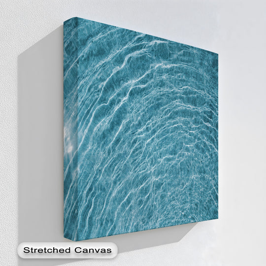 The textured white wall and deep shadow around the abstract blue water ripple best canvas prints create striking negative space.