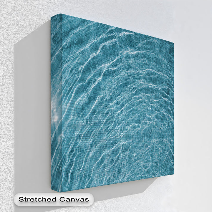 The textured white wall and deep shadow around the abstract blue water ripple best canvas prints create striking negative space.