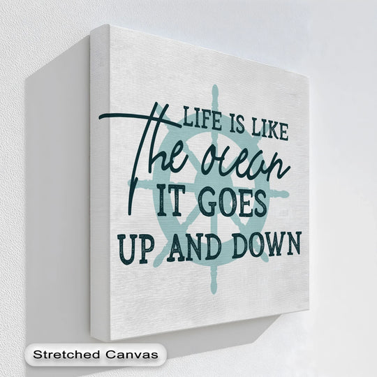 Visual rhythm flows through this nautical quote canvas artwork featuring the phrase 'Life is like the ocean' with an anchor design.