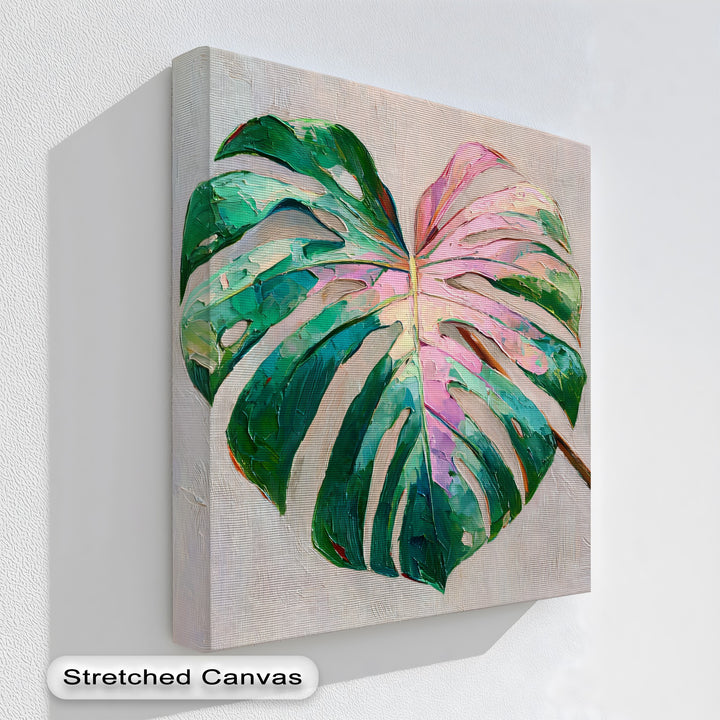 Negative space surrounds the vibrant pink monstera leaf in this hanging canvas print, creating a visually striking piece of botanical wall art.