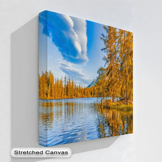 Wispy clouds reflecting in the calm water create the softest element in this golden lakeside autumn scene, printed on high-quality canvas wall decor.