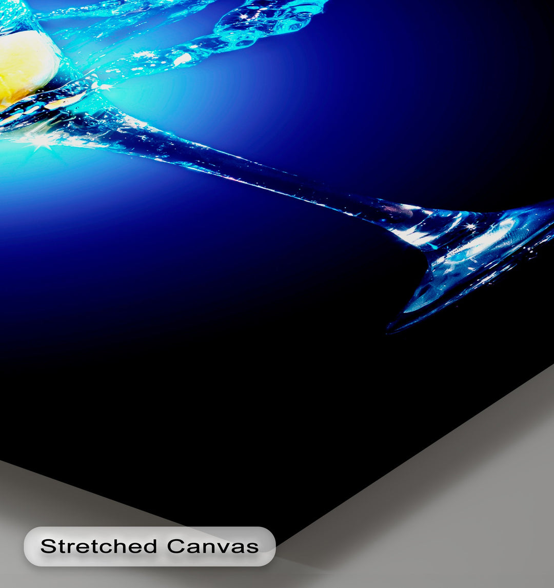 The deep blue background of this shimmering blue martini canvas wall decor gradually darkens to black.