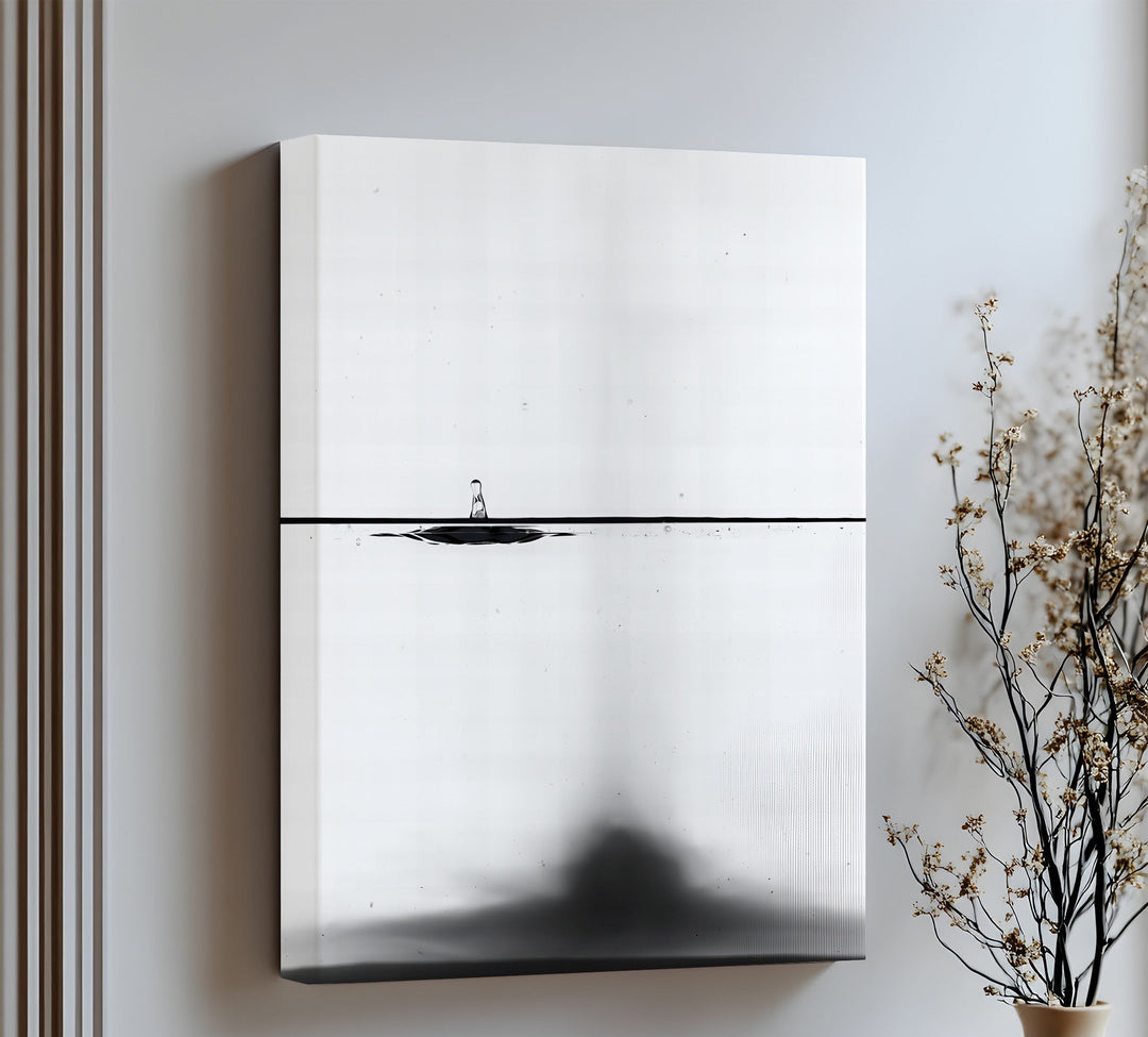 Minimalist elegance meets motion in this striking canvas wall art of a water drop in black and white.

