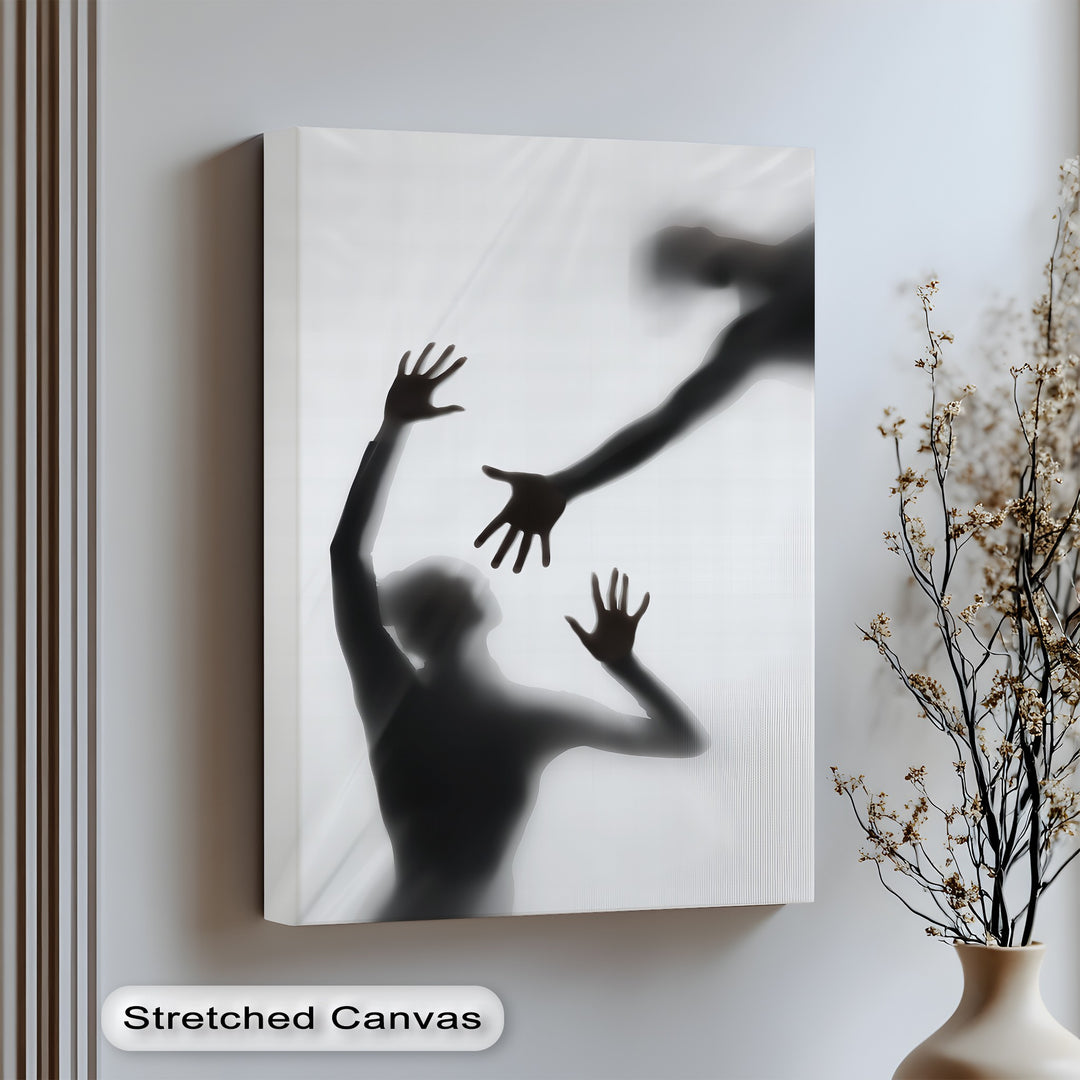 Silhouettes reach through shadows in this hauntingly beautiful canvas wall art of human connection.

