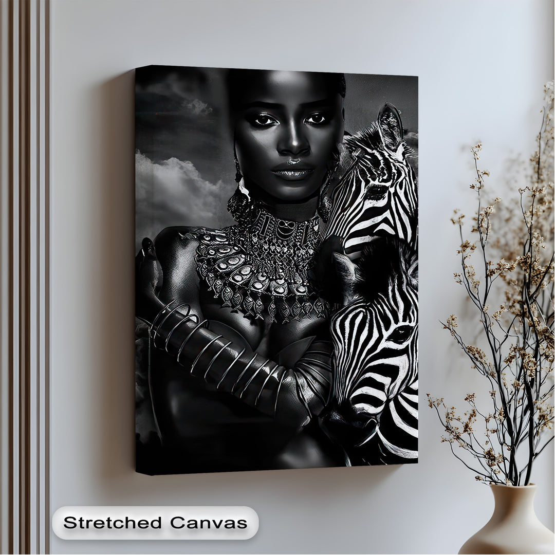 Showcasing realistic detail, this monochrome zebra canvas artwork features an elegant woman with intricate jewelry embracing a majestic zebra.